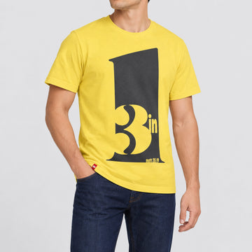 FIVE2 3 in 1 Trinity Tee in Yellow, front model view with a large charcoal numeral 1, negative-space 3 in lettering and Matthew 28:19.